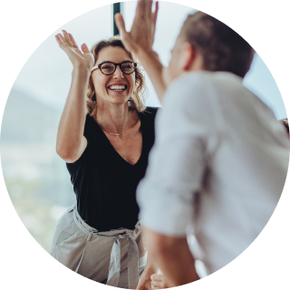 Two office workers giving each other a high five